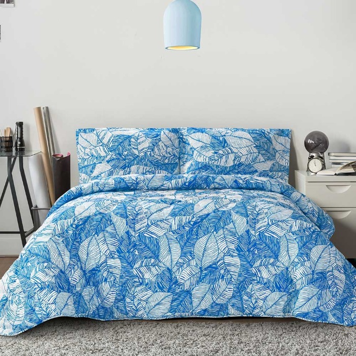 A bed with a blue comforter and pillows 