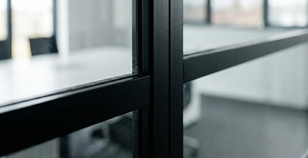 چگونه پارتیشنبندی اصولی میتواند فضای اداری کوچک را بزرگتر نشان دهد؟ نمای نزدیک از فریم ظریف پارتیشن شیشهای با طراحی مدرن